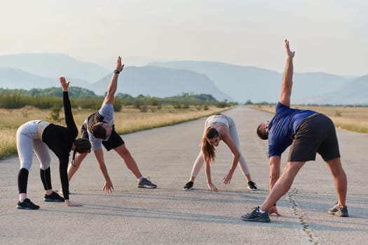 A determined group of athletes engage in a collective stretching session before their run, fostering teamwork and preparation in pursuit of their fitness goals.