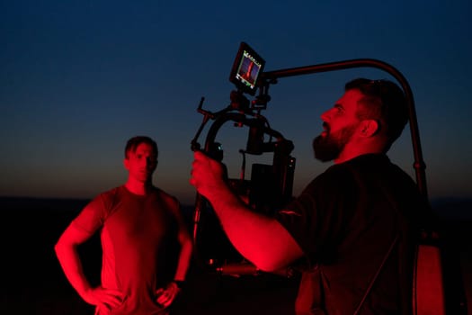 A skilled videographer captures the intensity of athletes running, illuminated by vibrant red lights, encapsulating the energy and determination of their nighttime training session.