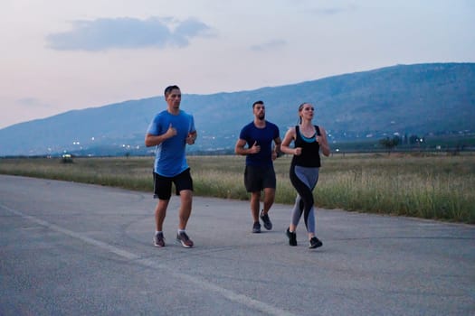 A diverse group of runners finds motivation and inspiration in each other as they train together for an upcoming competition, set against a breathtaking sunset backdrop.