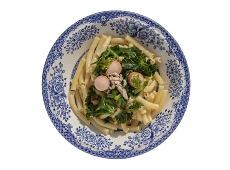 Plate of Penne pasta with Sausage, Pork and Kale isolated on white background with clipping path. Top view, Selective Focus.