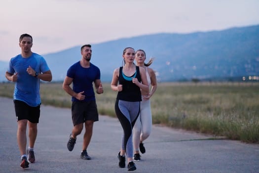 A diverse group of runners finds motivation and inspiration in each other as they train together for an upcoming competition, set against a breathtaking sunset backdrop.