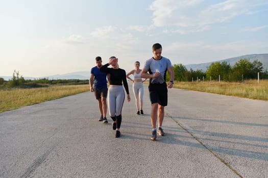 A group of friends maintains a healthy lifestyle by running outdoors on a sunny day, bonding over fitness and enjoying the energizing effects of exercise and nature.