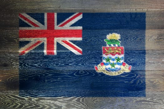 A Cayman Islands flag on rustic old wood surface background union jack ensign crest