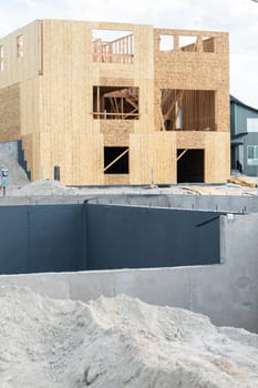 An ongoing construction site in the suburbs, featuring the foundation stage of a single-family house.