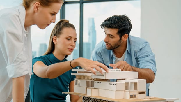 Smart architect team discussion about house design while handsome male worker present idea by using laptop. Group of professional engineer sharing, brainstorming design. Business design. Tracery