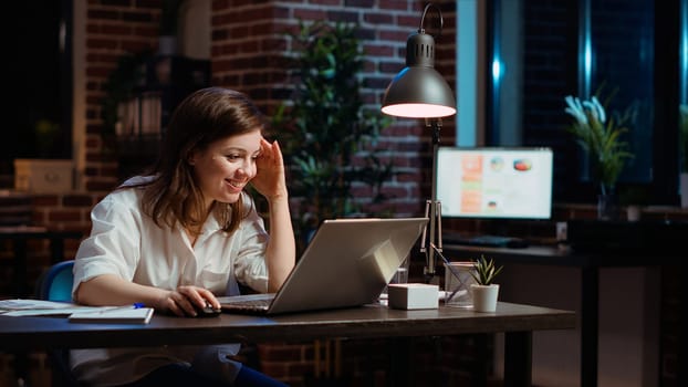 Happy employee reading email on laptop received from customer, excited after managing to secure lucrative deal for company. Businesswoman celebrating finalizing agreement with client, camera B