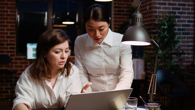 Worker brainstorming with colleague to write email at computer desk, finalizing deal with business partners. Coworkers using laptop to make agreement over internet with associates, zoom in shot