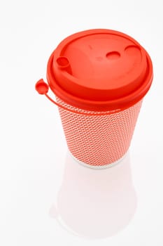 The pink cardboard coffee cup with a red plastic lid on the white glossy background, the inscription on the lid is Carefully Hot, transparent background. High quality photo