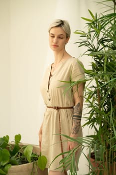 young beautiful woman posing in a beige dress in the studio