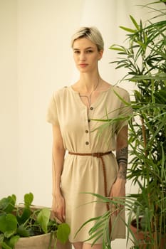 young beautiful woman posing in a beige dress in the studio