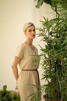 young beautiful woman posing in a beige dress in the studio