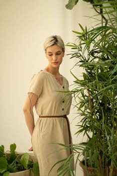 young beautiful woman posing in a beige dress in the studio