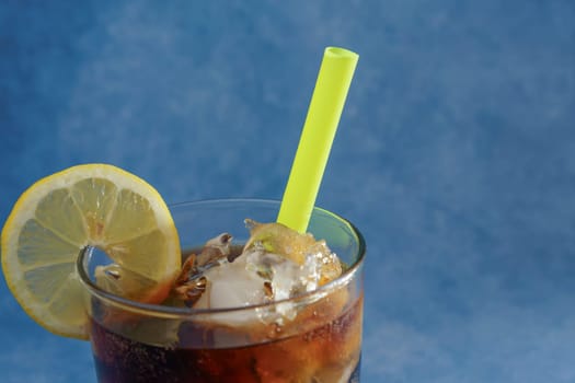 cola with ice and lemon and a yellow straw