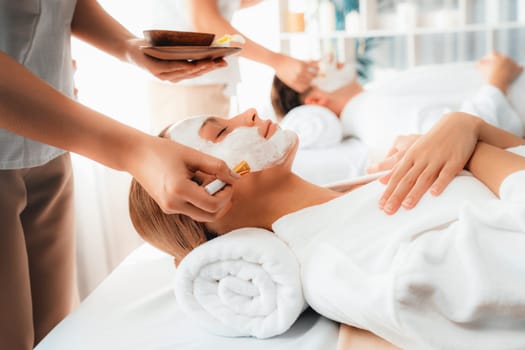 Serene ambiance of spa salon, couple indulges in rejuvenating with luxurious face cream massage with modern daylight. Facial skin treatment and beauty care concept. Quiescent