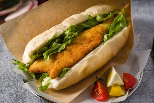 Fried fish sandwich with greens on the stone table. Turkish name Balik Ekmek