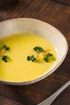 Top view of Italian corn soup on wooden table