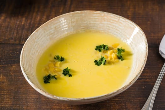 Top view of Italian corn soup on wooden table