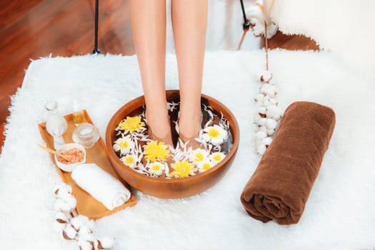 Woman indulges in blissful foot massage at luxurious spa salon while masseur give reflexology therapy in gentle day light ambiance resort or hotel foot spa. Quiescent