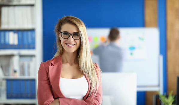 Portrait of blonde businesswoman with glasses in office. Business consulting concept