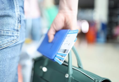 Man holding green briefcase and passport with plane tickets closeup. Business travel abroad concept