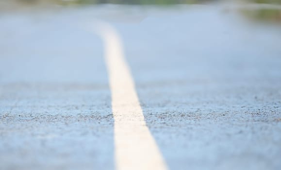 Closeup of white dividing strip on road. Cycling on bike path concept