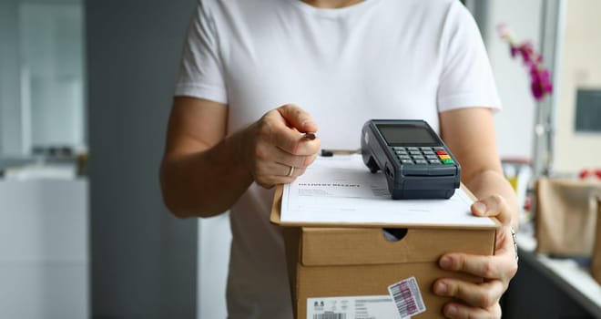 Male deliveryman hold silver pen in hand. Sign a supply contract concept