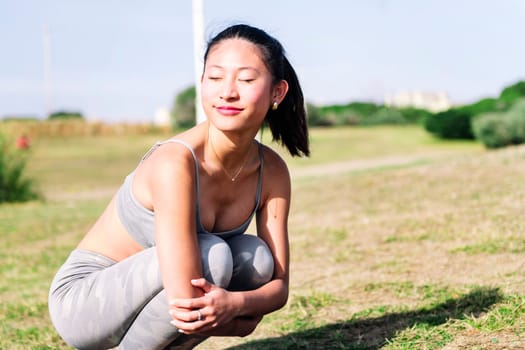 young asian woman in sportswear smiling happy in the park, sport and active lifestyle concept