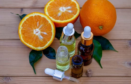 bottle of aromatic essence and fresh orange on the background of nature