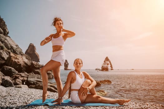 Woman sea yoga. Back view of free calm happy satisfied woman with long hair standing on top rock with yoga position against of sky by the sea. Healthy lifestyle outdoors in nature, fitness concept.