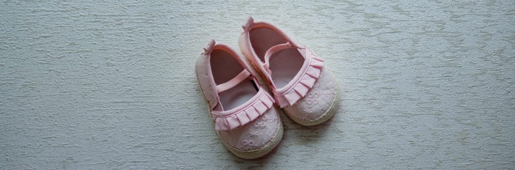 Children's shoes and teddy bear on a light background. Background with place for text.