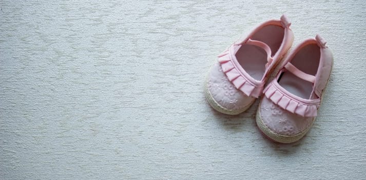 Children's shoes and teddy bear on a light background. Background with place for text.