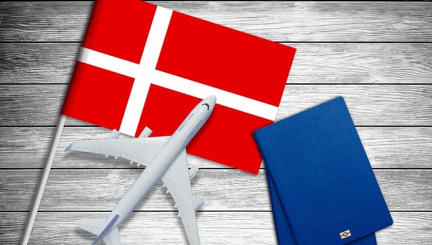 Traveling to Denmark, top view passenger plane on Denmark flag. High quality photo