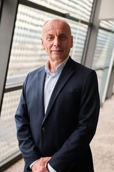 An older businessman exudes confidence in a contemporary conference room setting.