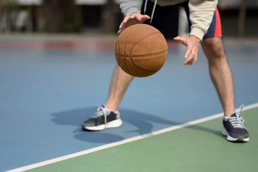 Athlete man playing basketball in an urban court. Sport and active lifestyle concept.