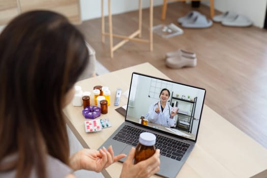 Senior Asian woman video calling with doctor on tablet, consultation health issues and medication online. Doctor concept of telemedicine.