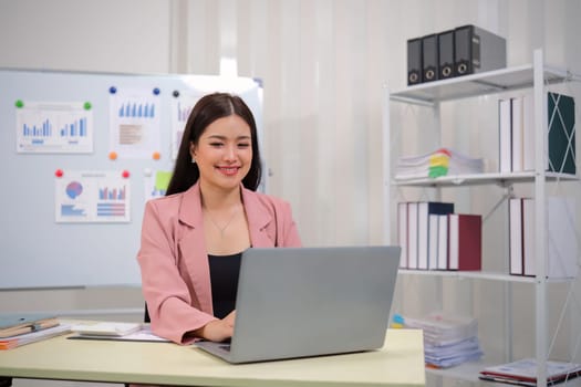 Businesswoman accountant using calculator and laptop for financial data saving in office room, Business financial, tax, accounting concept.