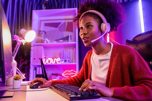 Host channel of gaming streamer, African girl wining with Esport skilled team player and viewers online game in neon color lighting room. Concept of cybersport indoor activities. Tastemaker.