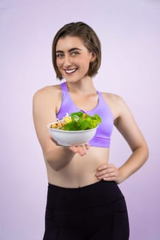 Full body length gaiety shot athletic and sporty young woman with healthy vegan food in standing posture on isolated background. Healthy active and body care by vegetarian lifestyle.