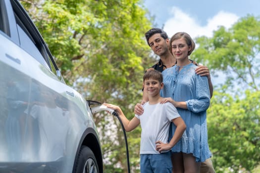 Family road trip vacation with electric vehicle, lovely family recharge EV car with green and clean energy. Natural and eco friendly car travel for sustainable environment. Perpetual