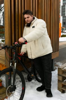 Young European man with a bicycle in an urban environment.