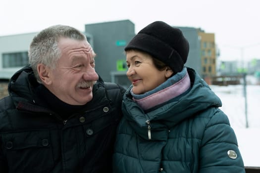 Mature husband and wife spend time together walking down the street in winter.