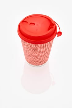 The pink cardboard coffee cup with a red plastic lid on the white glossy background, the inscription on the lid is Carefully Hot, transparent background. High quality photo