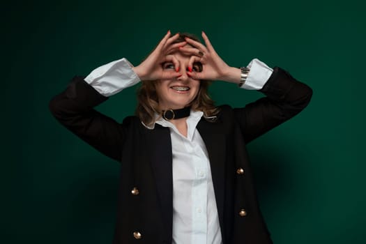 A woman is shown forming a heart shape with her hands against a neutral background. She is using both hands to create the heart symbol, with her fingers interlocking to complete the shape. The gesture signifies love, affection, and positivity.