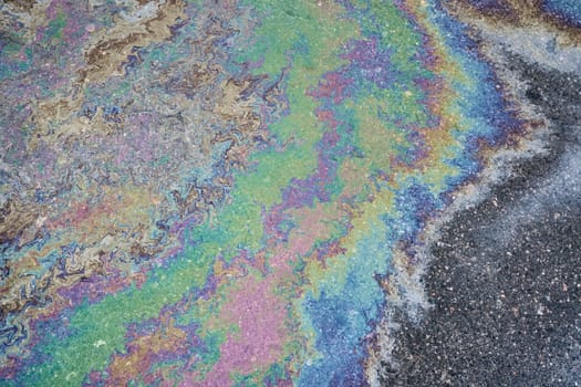 Leakage of oil or gasoline from a car onto a wet asphalt road. Environmental pollution concept