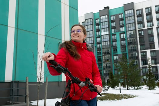 Active European woman pedaling a bicycle in winter.