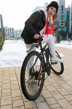A woman took a rented bicycle with her outside in winter.