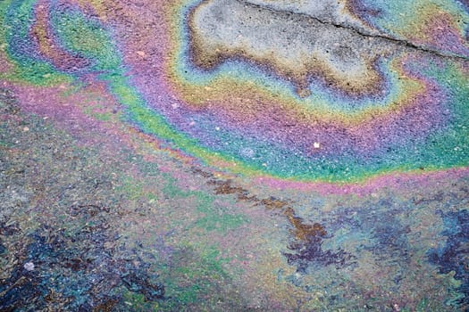 Abstract background from motor oil, gas or petrol spilled on asphalt.