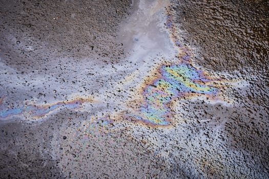 Bold multicolored spots on the asphalt. Concept of environmental problems