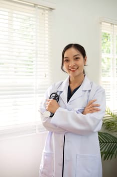 Confident female doctor Smiling woman standing holding stethoscope in clinic.