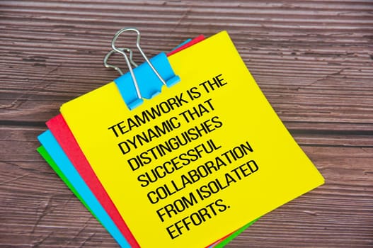 Teamwork related text on yellow notepad.